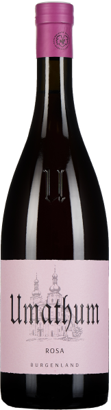 Dunkle Weinflasche mit elegant geschwungener Form, tiefrote Flüssigkeit erkennbar. Das Etikett ist zart rosa mit einer stilisierten Zeichnung von Türmen. Der Verschluss in einem kräftigen Rosaton.