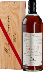 Eine elegante Flasche Whisky mit tiefem Bernsteinton, präsentiert in einer edlen Holzkiste mit rotem Band.