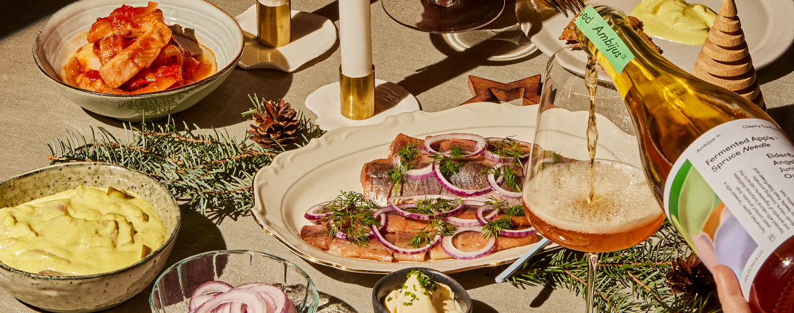 Festlich gedeckter Tisch mit Speisen, Kerzen und einem Glas, das gerade eingeschenkt wird.