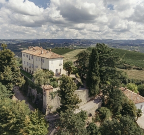 Luftaufnahme einer Villa mit roten Ziegeldächern, umgeben von grünen Weinbergen.