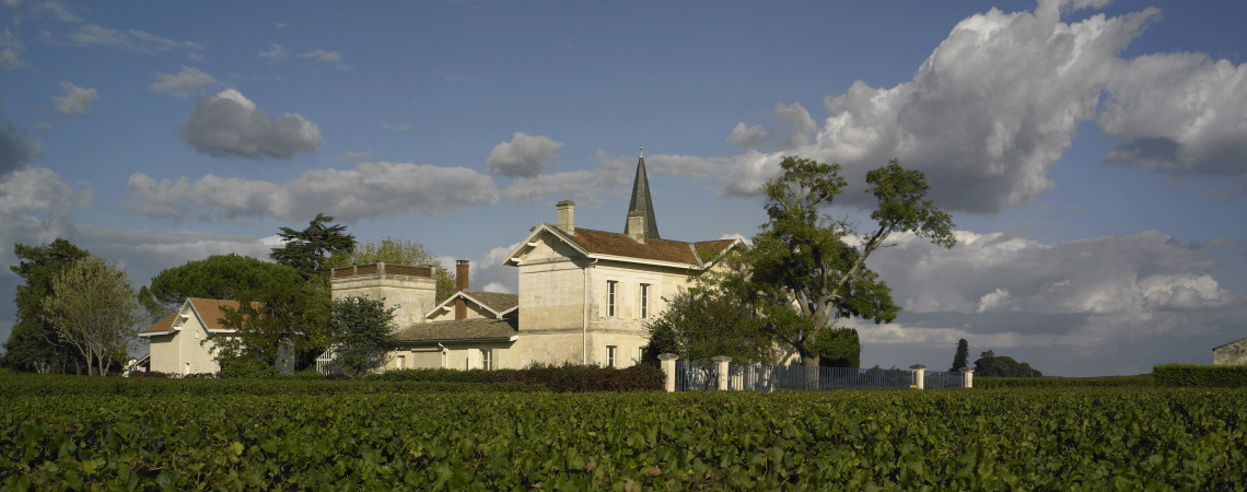 Malerische Weingut-Szenerie mit historischen Gebäuden und bewölktem Himmel.