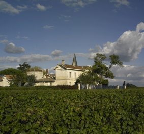 Malerische Weingut-Szenerie mit historischen Gebäuden und bewölktem Himmel.