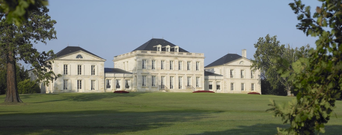 Großes, elegantes Herrenhaus mit symmetrischer Fassade auf weitläufiger Grünfläche.