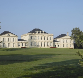 Großes, elegantes Herrenhaus mit symmetrischer Fassade auf weitläufiger Grünfläche.