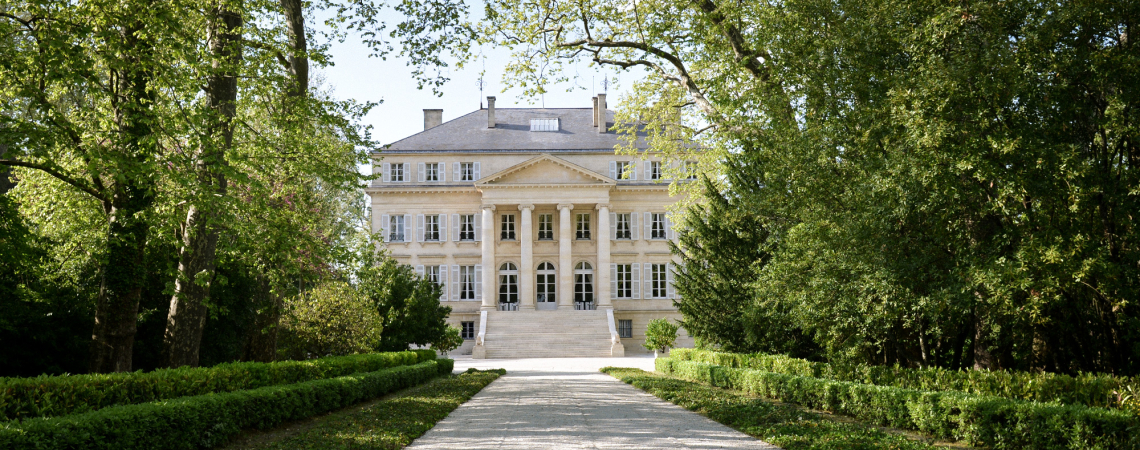 Elegantes Herrenhaus mit symmetrischer Fassade, umgeben von üppigem Grün und gepflegtem Gartenweg.