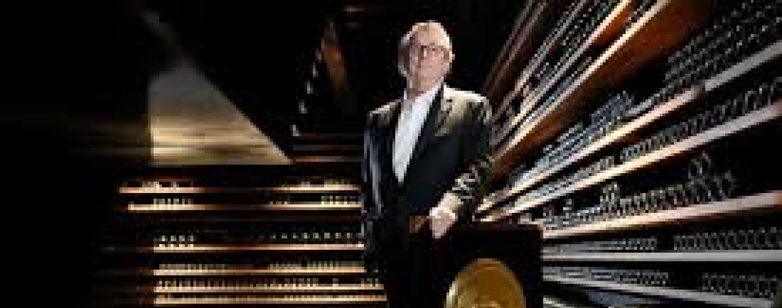 Eleganter Mann in Anzug steht neben einer goldenen Auszeichnung in modernem Raum.