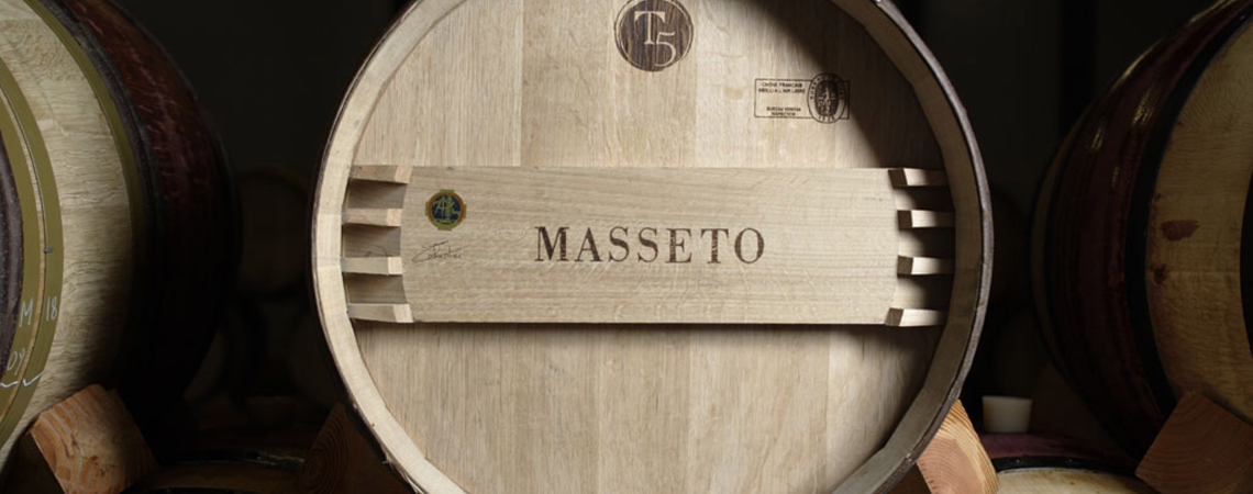 Holzfass in einem dunklen Weinkeller, mit klar sichtbarer Maserung und Beschriftungen.