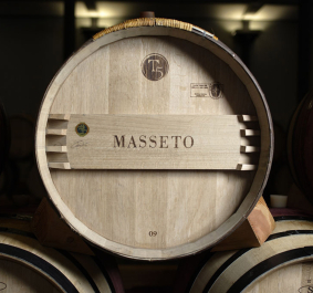 Holzfass in einem dunklen Weinkeller, mit klar sichtbarer Maserung und Beschriftungen.