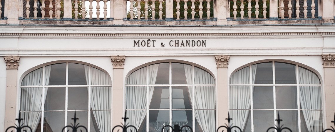 Elegante Fassade mit großen Bogenfenstern und geschwungenen weißen Vorhängen.