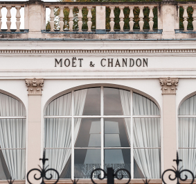 Elegante Fassade mit großen Bogenfenstern und geschwungenen weißen Vorhängen.