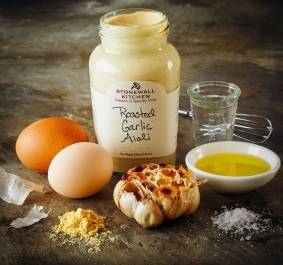 Glas Aioli mit Knoblauch, Eiern, Öl und Salz auf rustikalem Hintergrund.