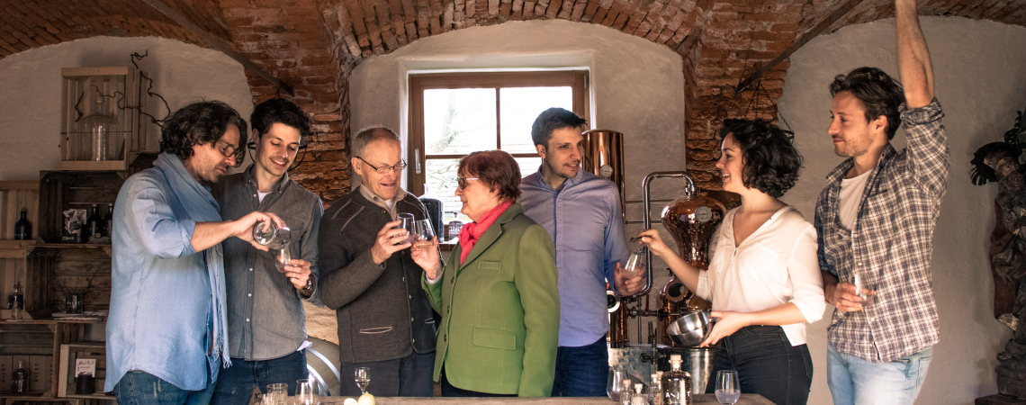 Gruppentreffen in rustikalem Raum mit Ziegeldecke und Tisch voller Gläser.