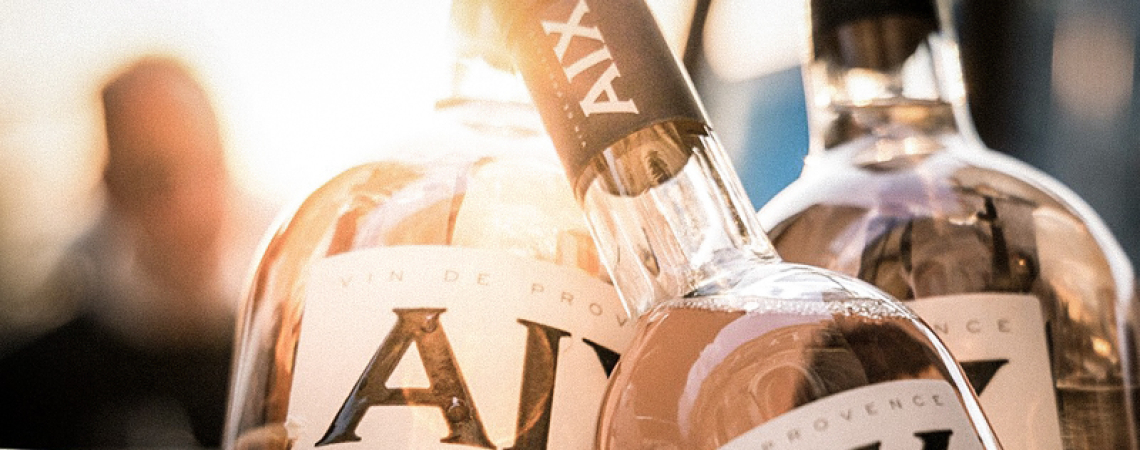 Drei Roséweinflaschen mit eleganten Etiketten in warmem Licht.