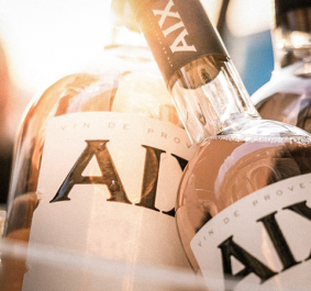 Drei Roséweinflaschen mit eleganten Etiketten in warmem Licht.