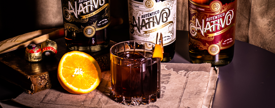 Drei Rumflaschen mit Cocktail, Schokolade und Orangenscheibe auf stilvollem Hintergrund.