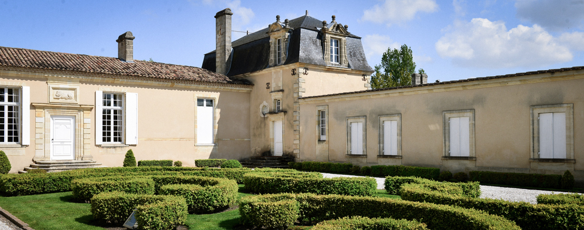 Herrenhaus mit klassischer Fassade und gepflegtem Garten im französischen Stil.