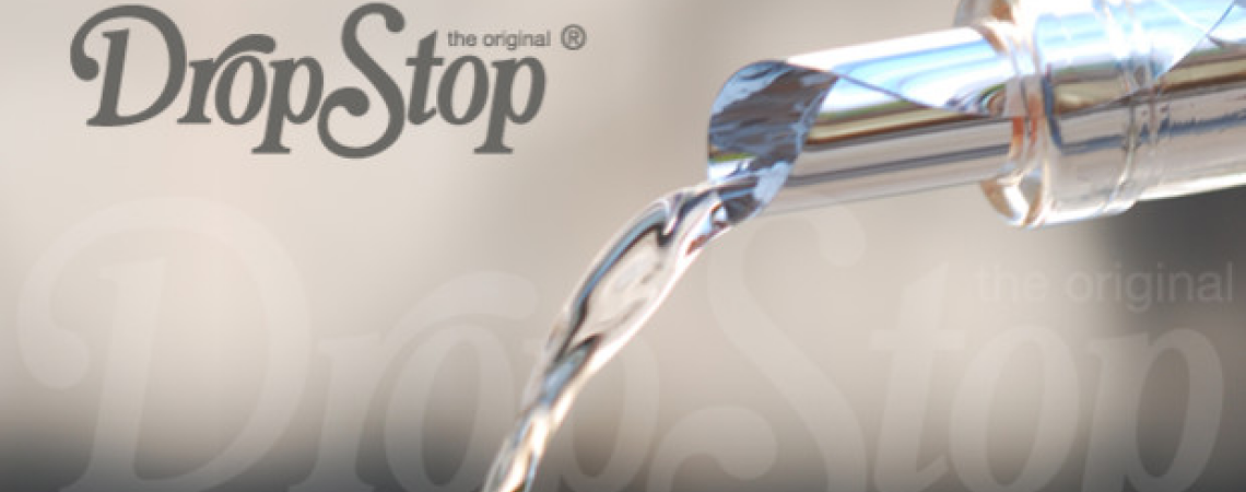 Silberner Ausgießer mit fließendem Wasser vor unscharfem Hintergrund.