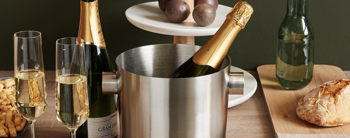 Edelstahleiskübel mit Champagnerflaschen, Holzplatte mit Brot und dreistöckiger Etagere.