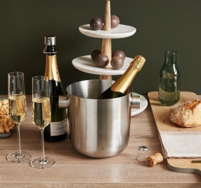 Edelstahleiskübel mit Champagnerflaschen, Holzplatte mit Brot und dreistöckiger Etagere.