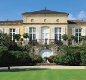 Grandioses Anwesen mit symmetrischer Fassade, großen Fenstern und gepflegtem Garten.