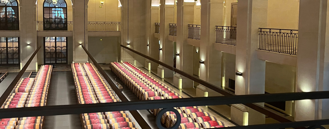 Weinkeller mit zahlreichen Holzfässern in symmetrischen Reihen.