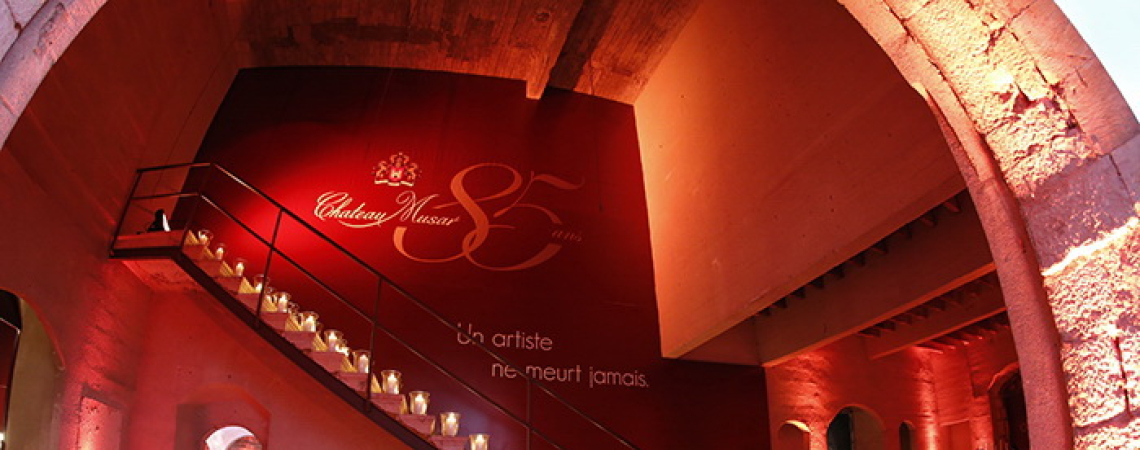 Stimmungsvolle, rot beleuchtete Treppe mit Kerzenarrangement in architektonischem Innenraum.