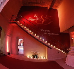 Stimmungsvolle, rot beleuchtete Treppe mit Kerzenarrangement in architektonischem Innenraum.