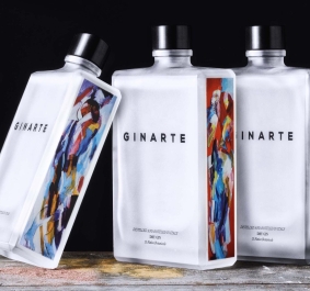 Drei eckige Ginflaschen, weiße Etiketten mit bunten, abstrakten Kunstwerken an den Seiten.