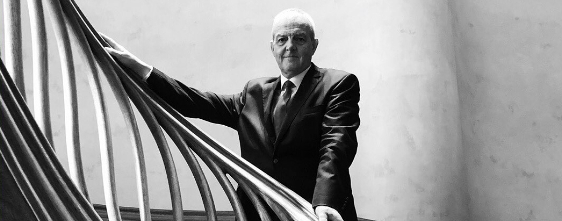 Eleganter Mann in Anzug auf kurviger, moderner Holztreppe; monochromes Design.