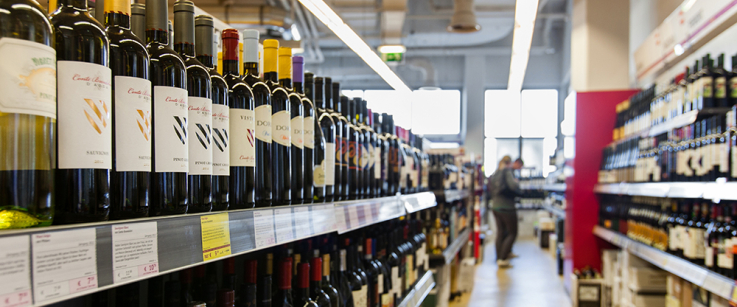 Regalreihen mit Weinflaschen in einem gut beleuchteten Geschäft.