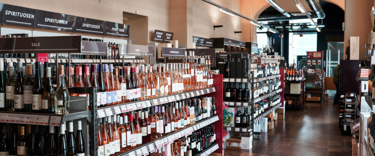 Regale mit Weinflaschen in einem gut beleuchteten Weinladen.