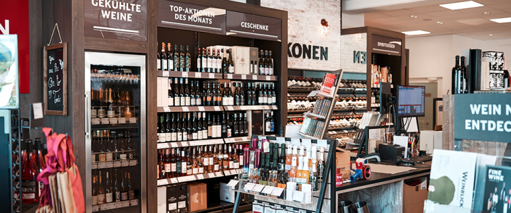 Modernes Weinregal in einem stilvollen Geschäft mit gut beleuchtetem Inneren.