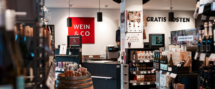 Gemütlicher Weinladen mit Holzelementen und Weinflaschen auf Regalen.