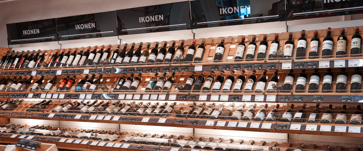 Weinregal mit zahlreichen Flaschen, übersichtlich präsentiert in einem Laden.