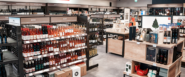 Moderner Weinladen mit Regalen voller Weinflaschen und Geschenkkörben.