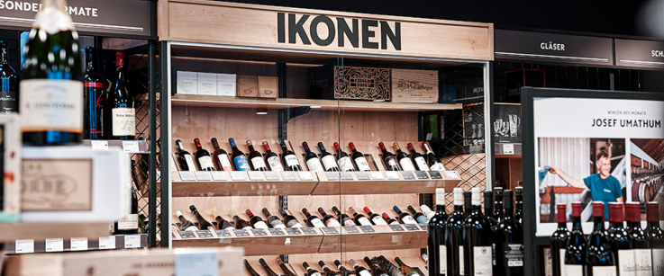 Weinregal im Geschäft mit verschiedenen Flaschen und Holzkisten.