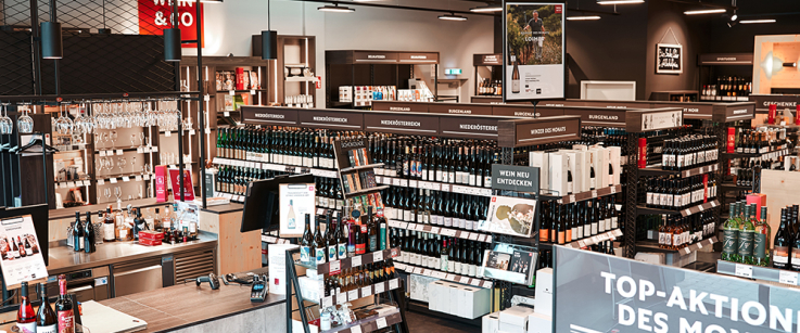 Moderner Weinladen mit Regalen voller Weinflaschen und stilvoller Dekoration.