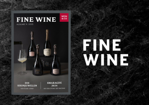 Zeitschrift mit Champagnerflaschen und Weinglas auf schwarzem Marmorhintergrund.