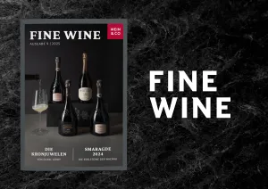 Zeitschrift mit Champagnerflaschen und Weinglas auf schwarzem Marmorhintergrund.