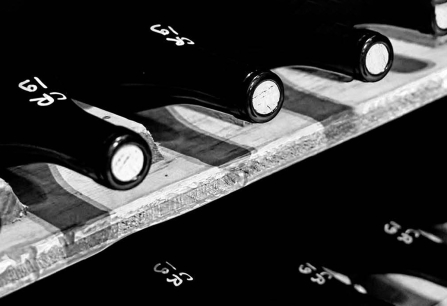 Nahaufnahme von Weinflaschen in einem Regal, in schwarz-weiß gehalten.